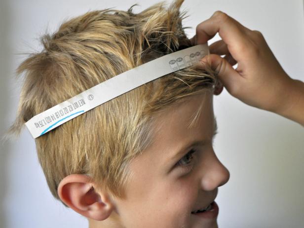 Cut open cereal box. Cut one long strip of cardboard and 20-25 leaves. Take cardboard strip and hold around head of the costume wearer to gauge size. Cut to length and use hot glue gun to glue ends together to create a headband. Hot glue leaves onto front half of the headband. Spray paint wreath gold.