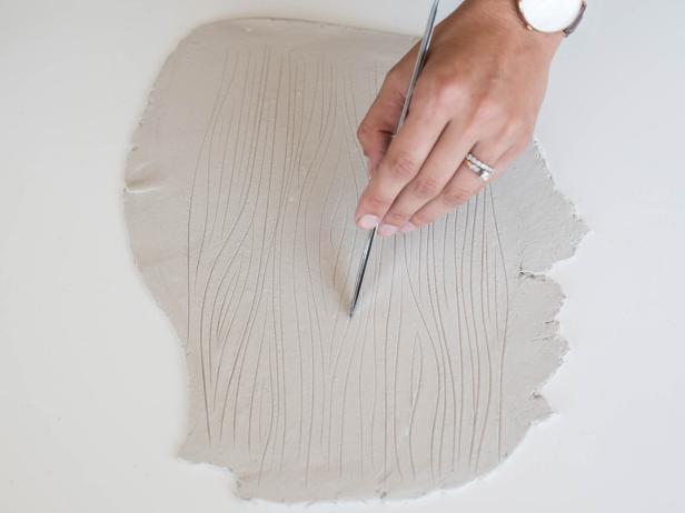 Use stamps or plastic knife to create a pattern in rolled-out clay. Tip: Clay can also be imprinted with fabric, lace, flowers, leaves, shells, etc. Test it out and, if it doesn't look good, just roll out the clay and try again. The options really are endless!