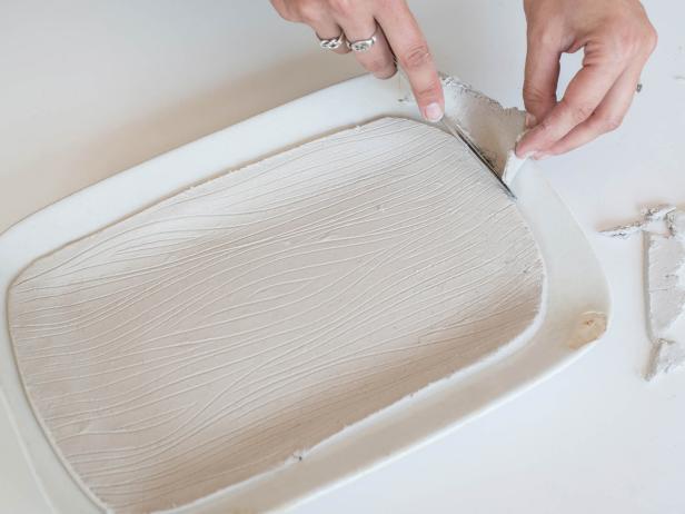 Carefully place clay inside a platter, bowl, or plate in desired shape. Gently press clay into the form of platter. Don't press too hard or the design will be damaged. Cut rough edges with plastic knife and smooth out with a finger. The edges will be sanded once clay is dry, so it doesn't have to be perfect at this stage. Allow clay to dry until hardened per instructions (usually about 24-72 hours).