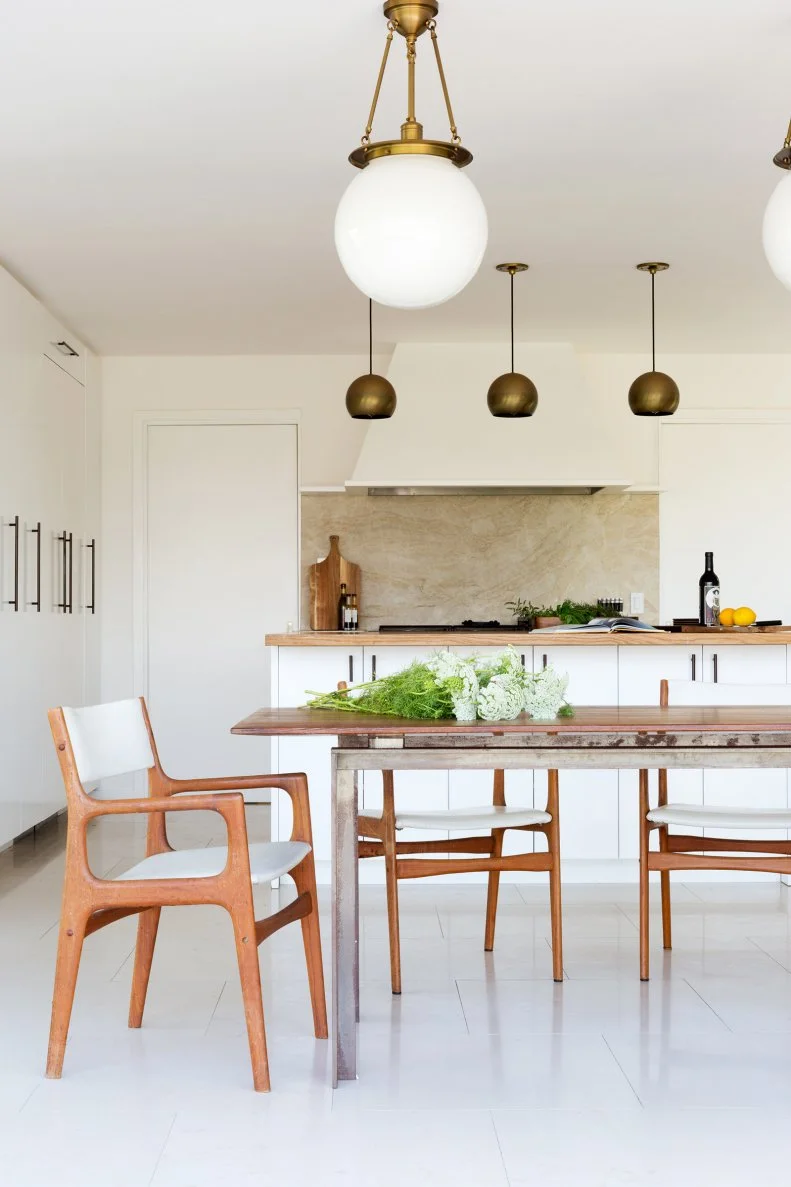 White Kitchen and Dining Space With Pendant Lights