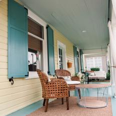 Yellow and Blue Front Porch with Brown Wicker Chairs 
