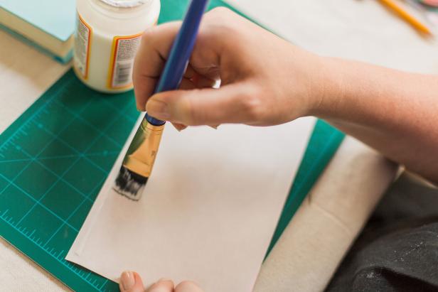 Brush the back of the decorative paper with glue, then smooth the paper onto back, spine and cover of your book.