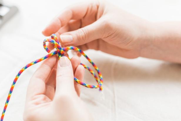 Take the right side of the cord and loop it over. Repeat the right-side loop on the “inside” of the loop you just made, making sure you are looping over both sections (Image A).
