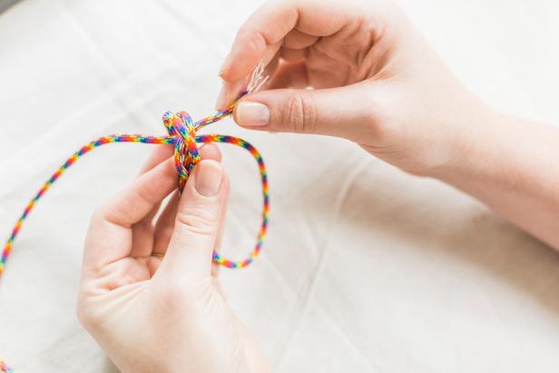 Take the right side of the cord and loop it over. Repeat the right-side loop on the “inside” of the loop you just made, making sure you are looping over both sections (Image A).