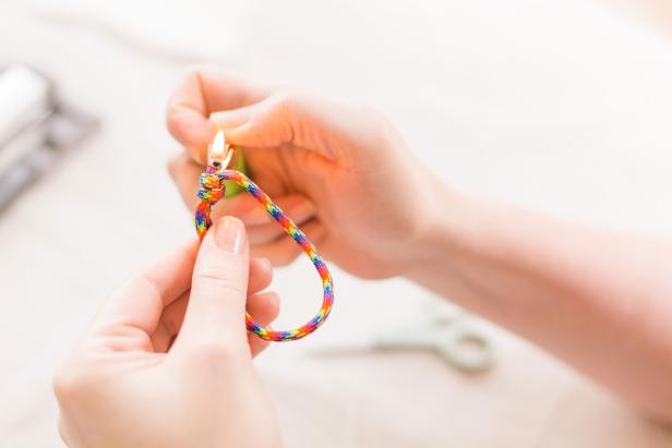 Seal frayed ends with a lighter but make sure not to melt the ends into the knot, as you will need these knots to move freely to adjust your bracelet (Image B).