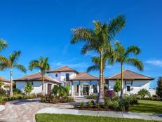 Coastal Home With Stucco Exterior and Roundabout Driveway