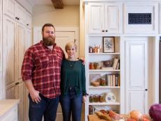 As seen on Home Town, hosts Ben and Erin Napier (L) stand in the newly renovated kitchen. After the renovations, the Carson's Laurel, MS kitchen now features a completely renovated French Country styled kitchen with new distressed cabinet doors, new appliances, new floor and wall tile, new heart pine reclaimed beams and a custom built Scotsman white oak table built by host Ben Napier. (portrait)