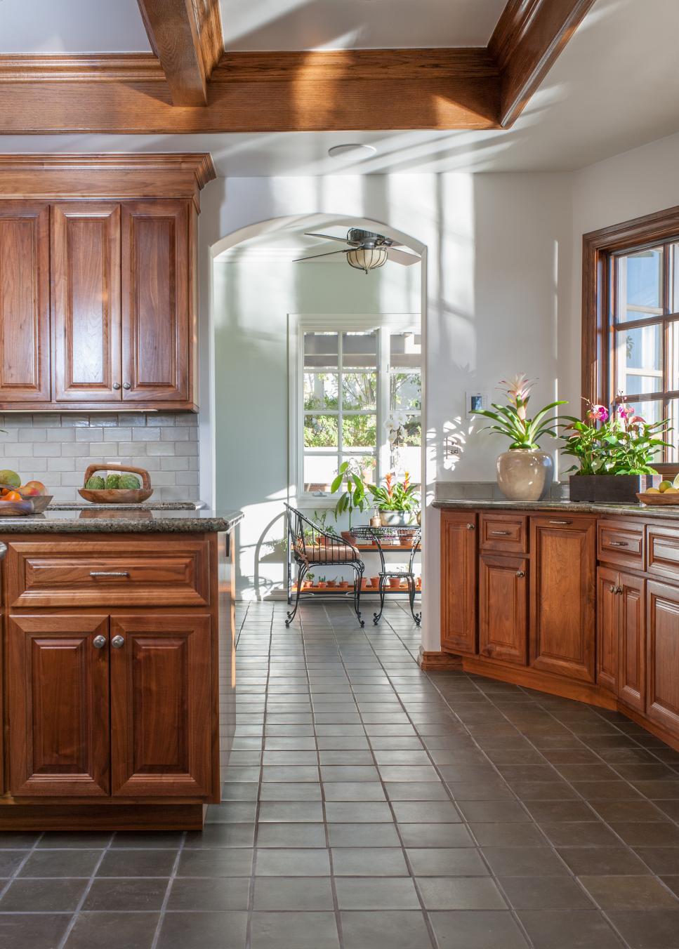 Sunny Kitchen Conservatory With Gray Tile Flooring, Arched Doorway and Walnut Wood Details Neutral Traditional Kitchen