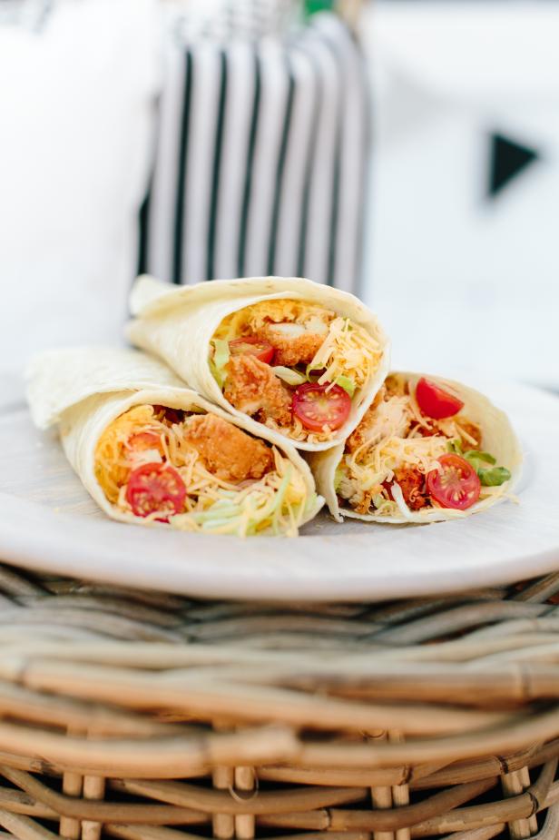 Here's a super easy idea for game day. These delicious buffalo chicken wraps feature a hint of buffalo spice, cooled off by the ranch and fresh vegetables. They are sure to be a crowd favorite. Pre-make, wrap in parchment paper and store in the cooler, or setup a wrap making station at your tailgating party.