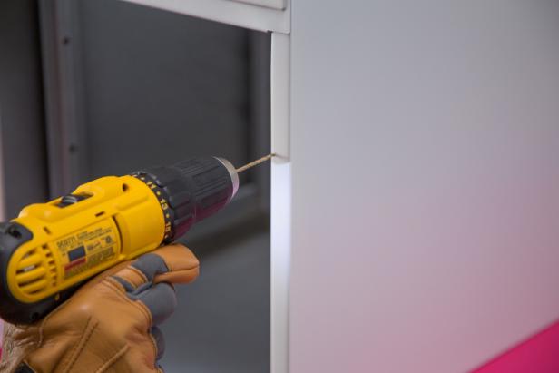 Drill pilot holes into the side of the cabinet.