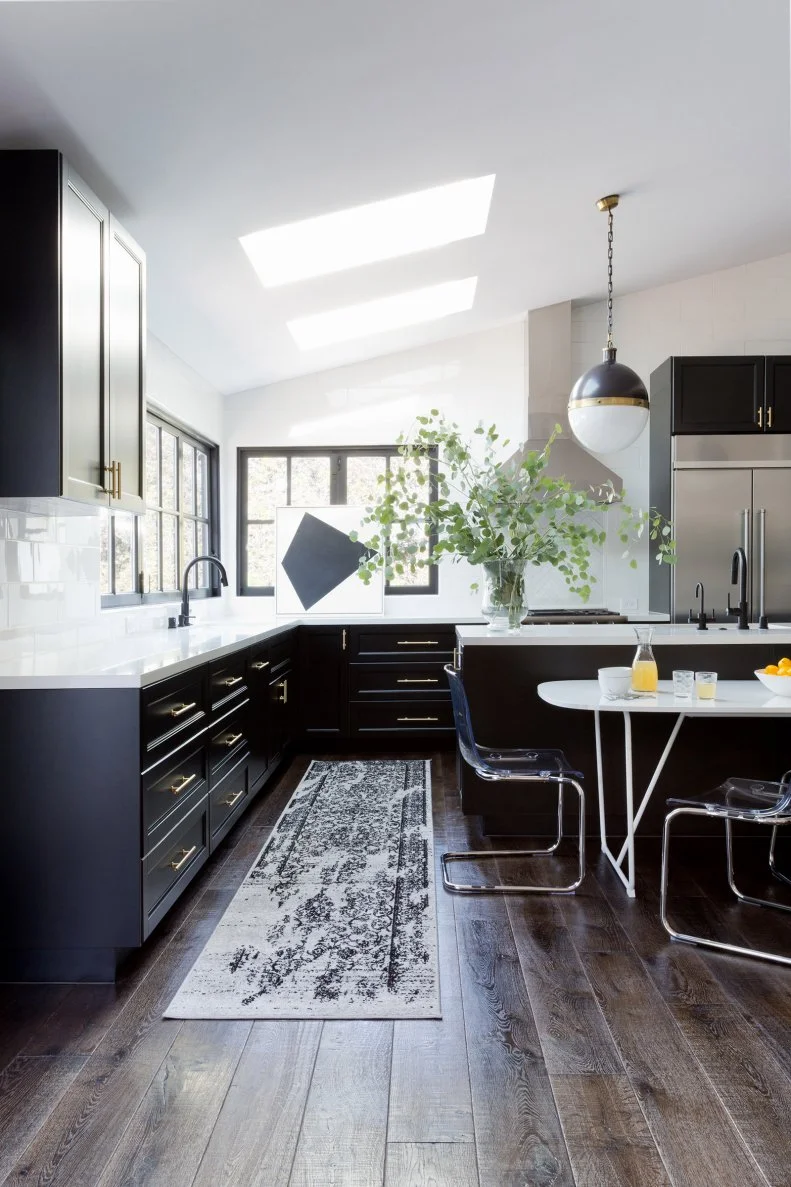 Kitchen With Skylights, Hardwood Floor and Black Cabinets