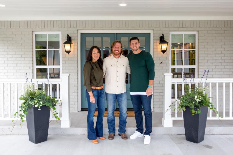 Chip and Joanna Gaines with Tim Tebow on the front porch of the Copp's newly renovated, as seen on Fixer Upper.