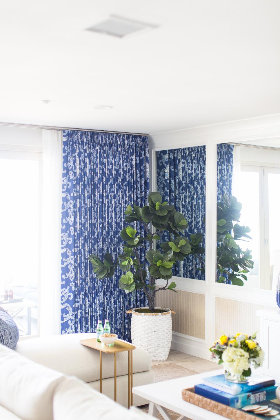 Contemporary White And Neutral Living Room With Blue Drapes And Mirror Accent Wall White And Neutral Living Room With Blue Curtains And White Sectional