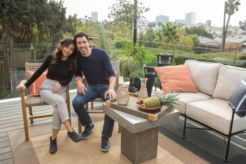 Drew Scott and fiancé Linda Phan enjoy a quiet moment on their new rooftop patio, with views of downtown of Los Angeles in the background, as seen on Property Brothers at Home: Drew’s Honeymoon House.