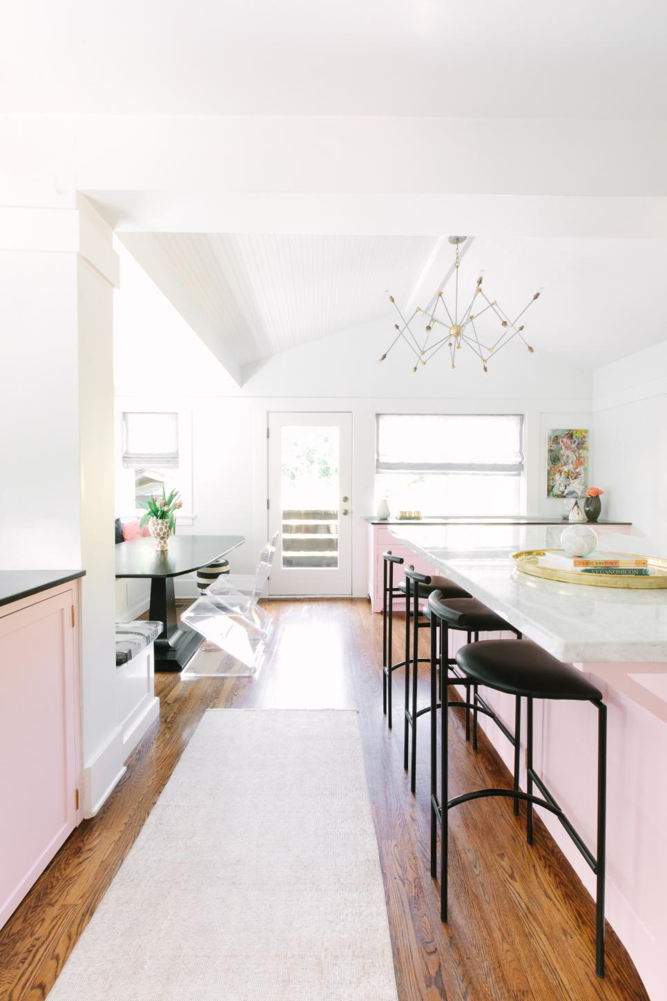 Pink Kitchen Island Complete With Chic Black Barstools contemporary kitchen with pink island