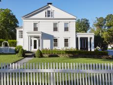 Traditional White Country Colonial With Landscaping And White Picket Fence