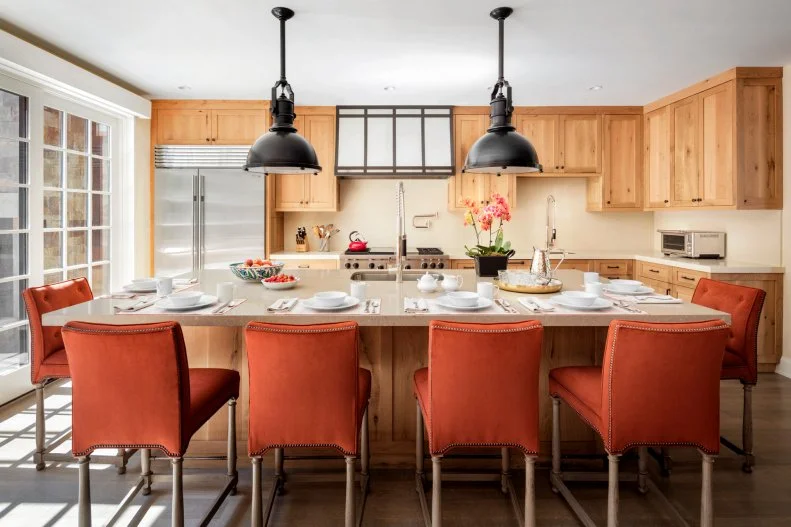 Large Kitchen Island Has Orange Seats, Black Industrial Pendant Lights