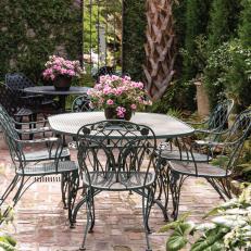 Brick Courtyard With Wrought Iron Tables And Chairs