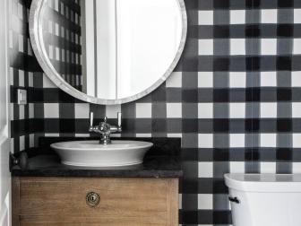It may seem counterintuitive, but choosing a bold color or an oversized pattern can actually make a small space look larger. This is exactly the approach designers Renee DiSanto and Christine Samatas of Park & Oak took, choosing the high-contrast combination of black and white and a large-scale checked pattern to give a tiny powder room an outsize personality.