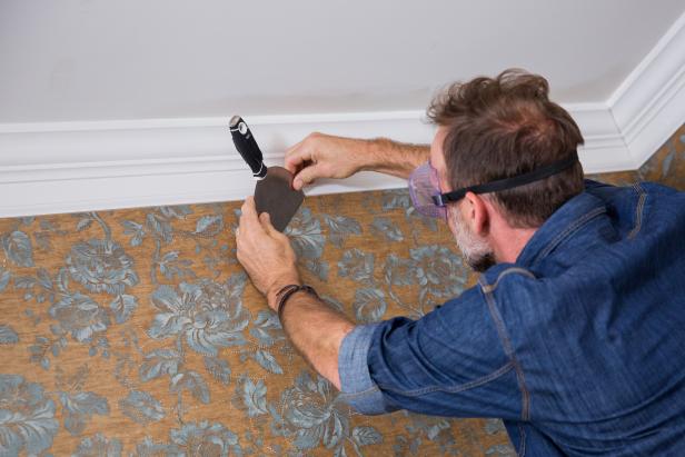 After a few minutes, use your rigid scraper to scrape the wet wallpaper and backing off of the wall.