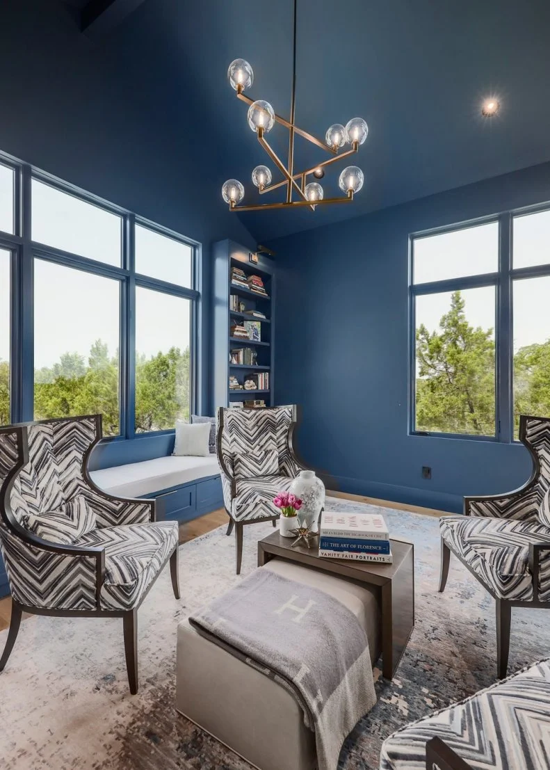Dark Living Room With Big Windows, Armchairs and Brass Chandelier
