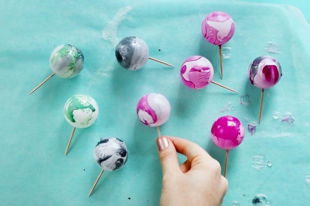 Switch it up by mixing different nail polish colors together and trying multiple colors. Let the completed balls dry on a sheet of wax paper.
