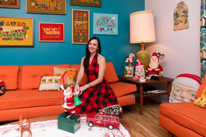 Woman Sits on Sofa In Living Room Filled with Vintage Holiday Decor