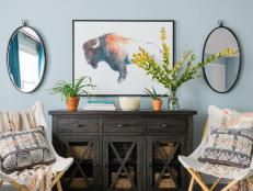 Symmetry is the name of the game on the art wall. To keep the area feeling balanced, a pair of chairs flanks the console table while a pair of ovular mirrors flanks the bison art above.