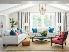 This neutral living room from HGTV Magazine is made lively with pops of color. Vaulted ceiling make the entire room feel more spacious.