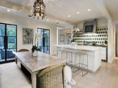 Large Dining Table Sits Beside Glass French Doors With Backyard View