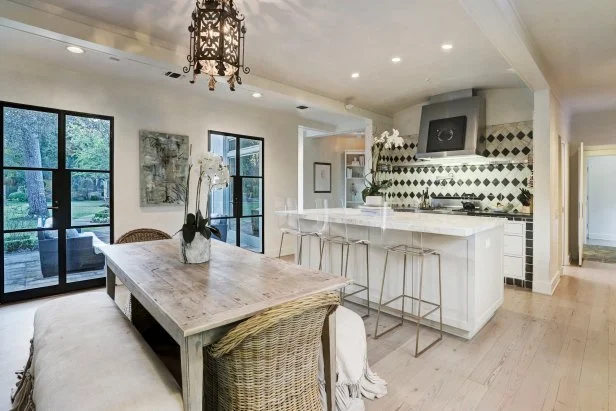 Large Dining Table Sits Beside Glass French Doors With Backyard View