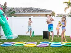Kids enjoying a backyard water fight, obstacle course and huge inflatable sprinkler. 