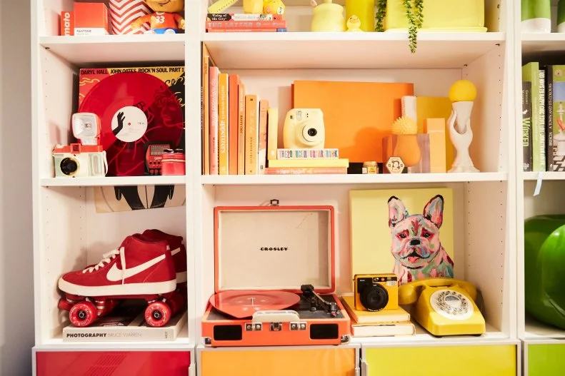 A Variety of Colorful Items Fill an Expertly Curated Bookshelf