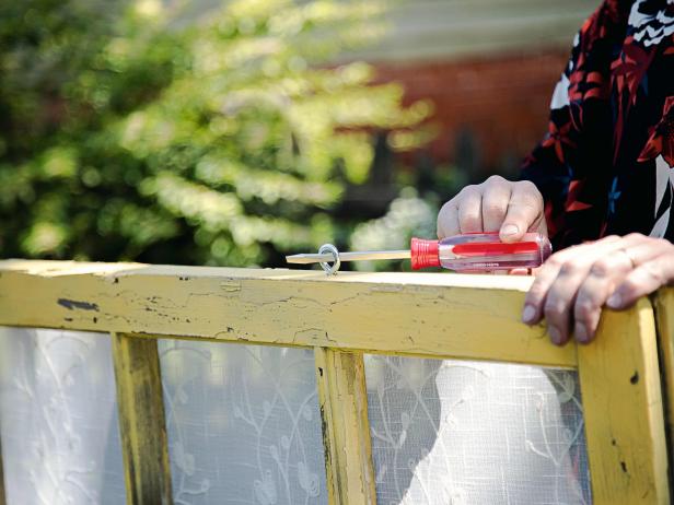 Attach two eye bolts to the top of each window frame.