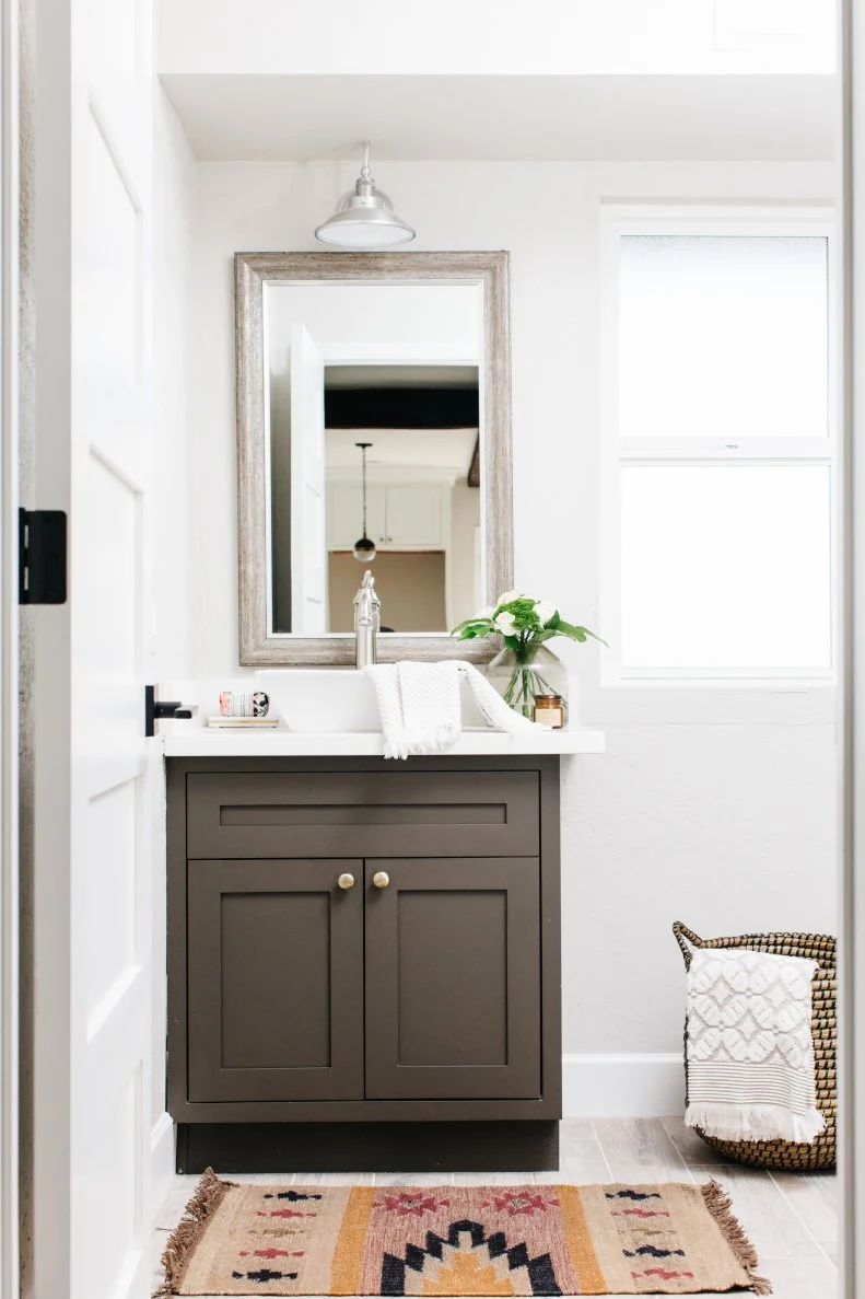 Small Vanity In Powder Room With Rustic Design And Patterned Rug