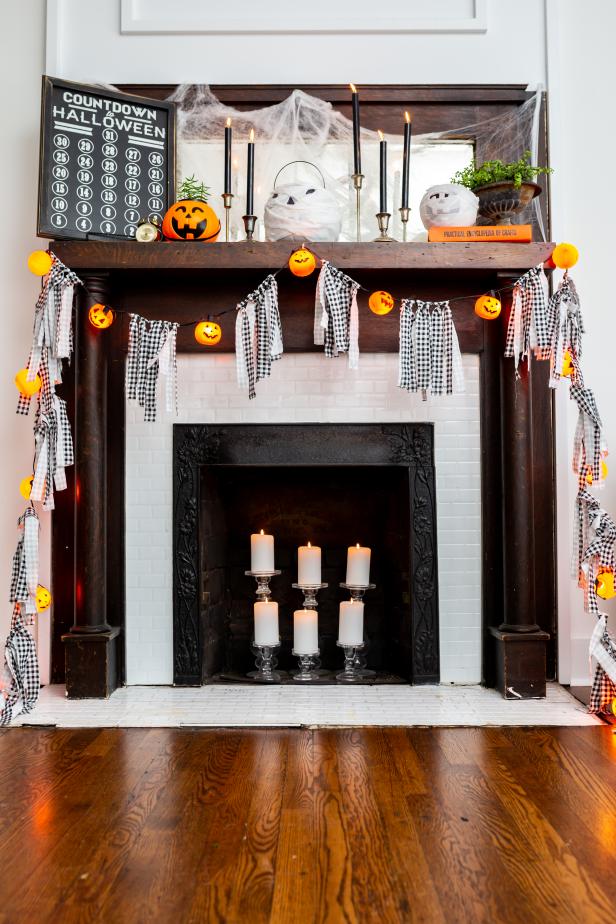 A Mantel Decorated With Plastic Pumpkin String Lights
