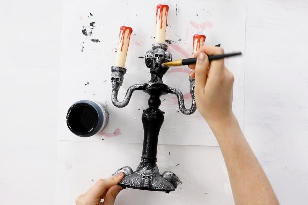 Start the project by painting the base of a Halloween candelabra black.