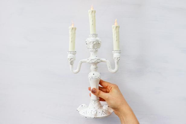 We painted this candelabra white and lightly sanded it to give it a weathered look to fit a farmhouse Halloween display.