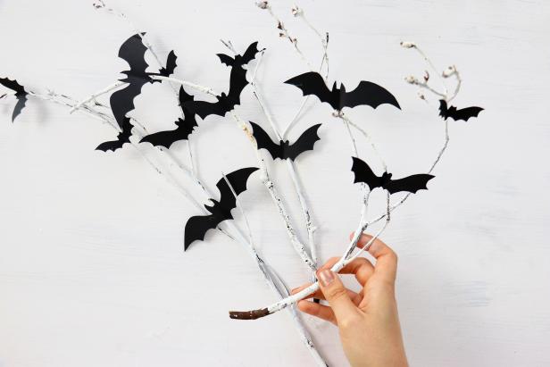 This simple projects uses branches and sticks collected from your backyard. Paint them white and lightly sand to give them a rustic, weathered look, then hot glue on paper bats. Once they are dry and you're satisfied with the look, you can arrange them in a vase.