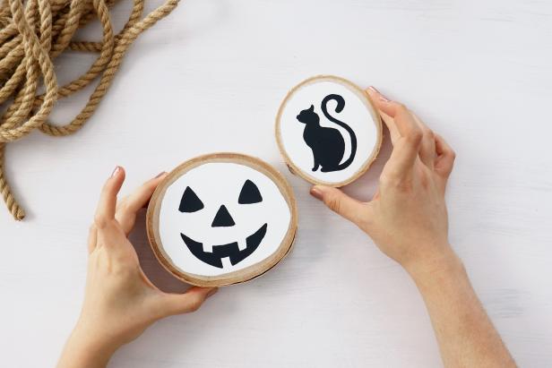 You can paint virtually any image onto these wood rounds for fall and Halloween decorating. We painted a jack-o'-lantern and cat silhouette onto a white background for a bright farmhouse look.