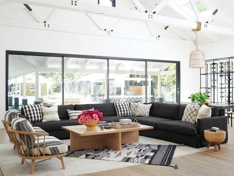 “I had this sectional made for my last house, so I was excited when it fit well in this space,” says Christina. She worked with local designer Raili Clasen to drop in unique pieces like the coffee table from HD Buttercup and the low-slung armchairs. All the blond wood balances out the charcoal gray fabric.