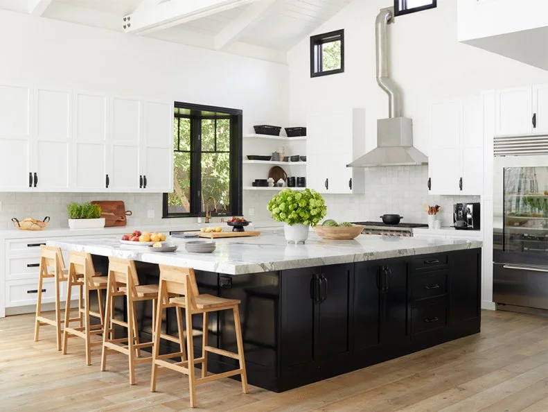 With a crisp palette and a large marble-top island already in place, it felt made for Christina and her family. She replaced most of the open shelves with upper cabinets. “I have more kids’ cups I’d rather hide away than cute knickknacks to display,” she says. The square tile backsplash is by Clé and the oak counter stools are from Industry West.