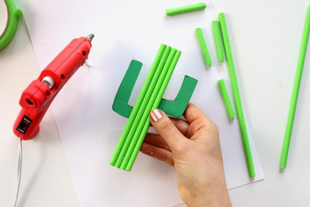 Cut down the straws to be slightly longer than the size of the cactus. Starting in the center of the cactus and working your way out, glue the straws in place with hot glue.