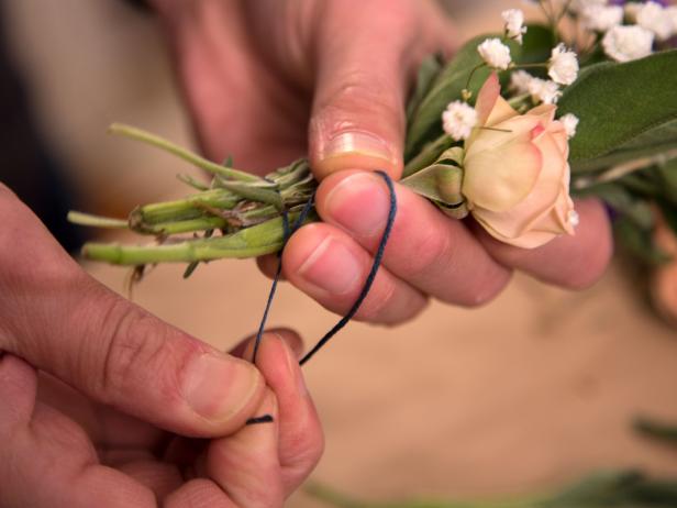 Cut a long piece of embroidery thread and tie around the stems of the bundle. Avoid using any kind of synthetic string. Wrap the thread around the stems several times. Since the bundle will shrink when dry, wrap very tightly to keep everything intact.