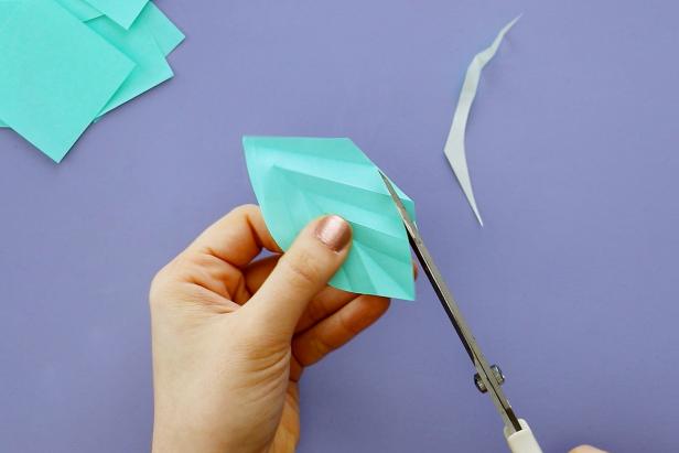 Unfold the paper and cut the edges into a leaf shape.