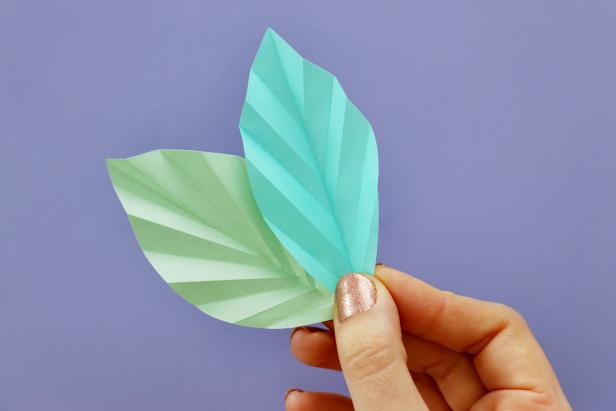 Unfold the paper and cut the edges into a leaf shape.