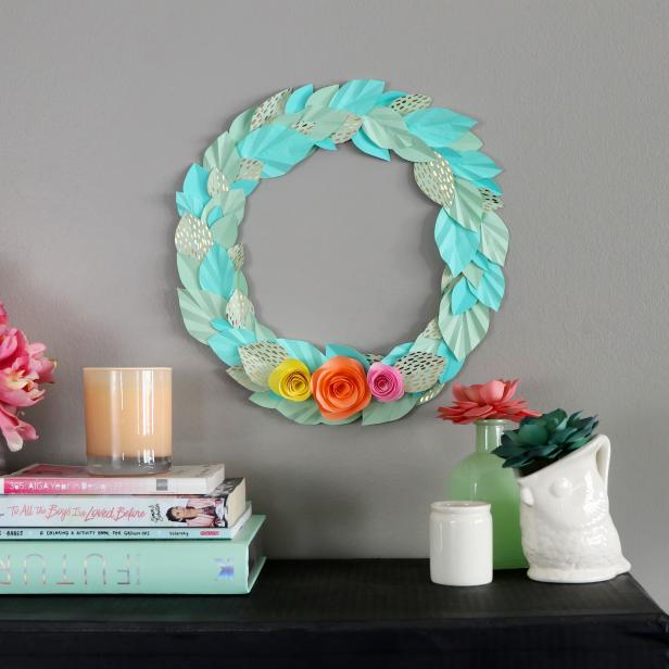 A completed origami paper wreath with colorful cardstock paper flowers .