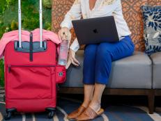 Woman sitting down using suitcase in hotel lobby or airport