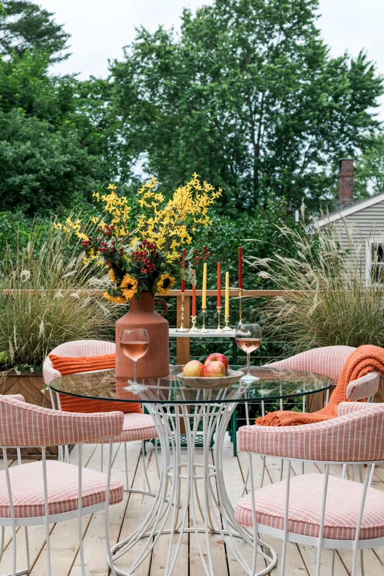 This breakfast nook puts a rust-toned twist on Fall style. Coral upholstery is accented with pumpkin-colored throws and accessories.