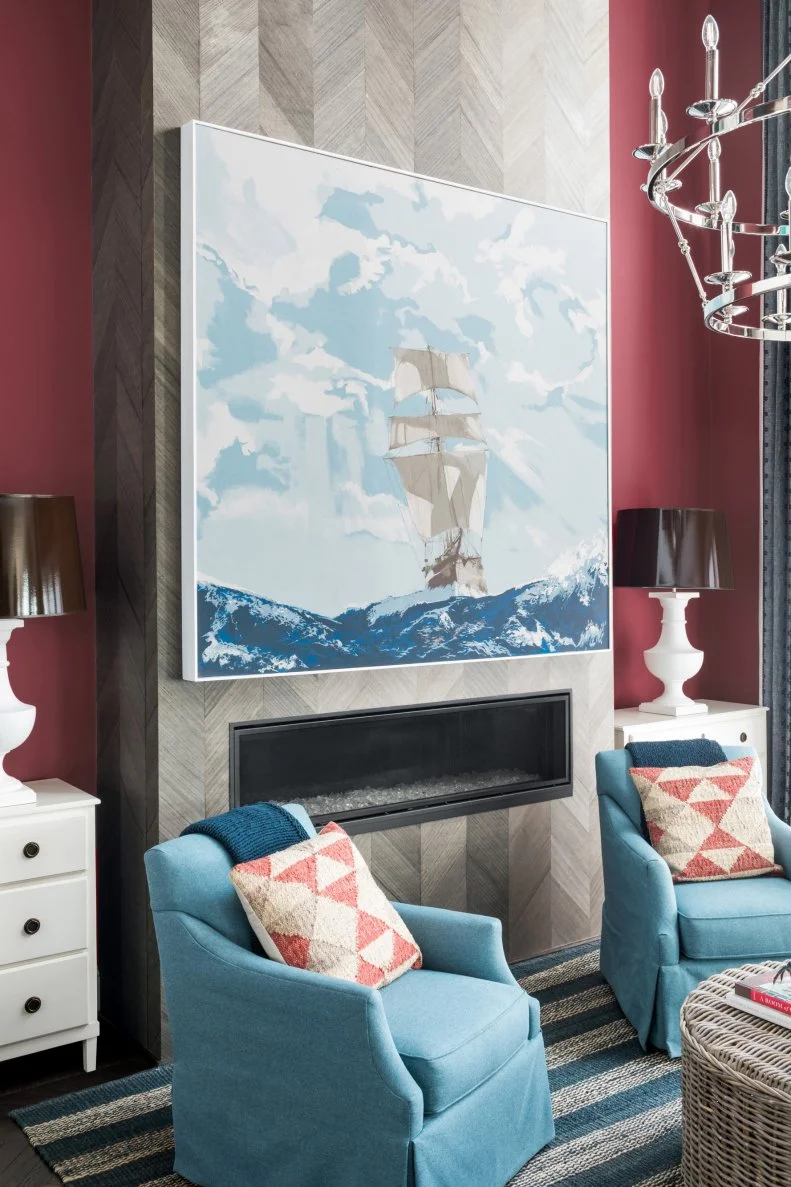 An original painting by artist John Gidding incorporates colors found throughout the interior of the home and brings a sense of place to the room by celebrating the area's nautical heritage.